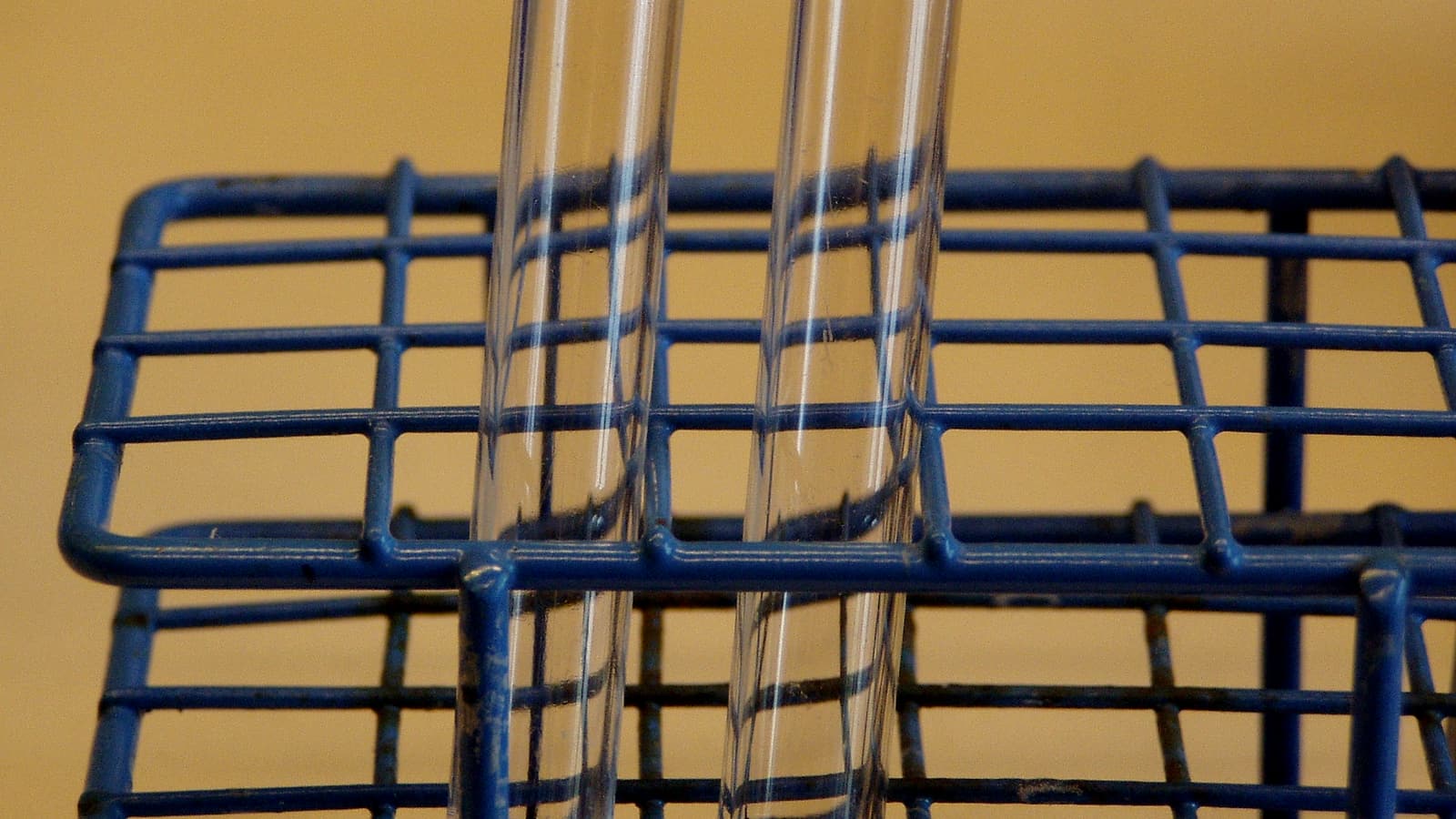 A small kitchen table with two mugs, a notebook and a set of keys, seen from above in even daylight